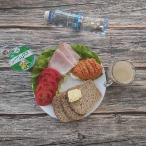 Zdjęcie przedstawia Dietę z ograniczeniem łatwo przyswajalnych węglowodanów: Chleb Graham Masło extra Pomidor Kefir Szynka krucha z pieca wieprzowa, parzona Woda mineralna Sałata zielona Hummus paprykowy